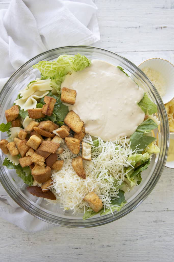 ingredients for caesar pasta salad in a bowl