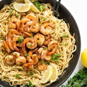 Cajun shrimp pasta in a pan with lemons and parsley