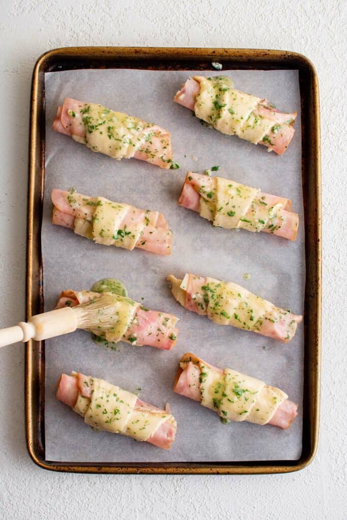 baking sheet with crescent rolls filled with ham and cheese