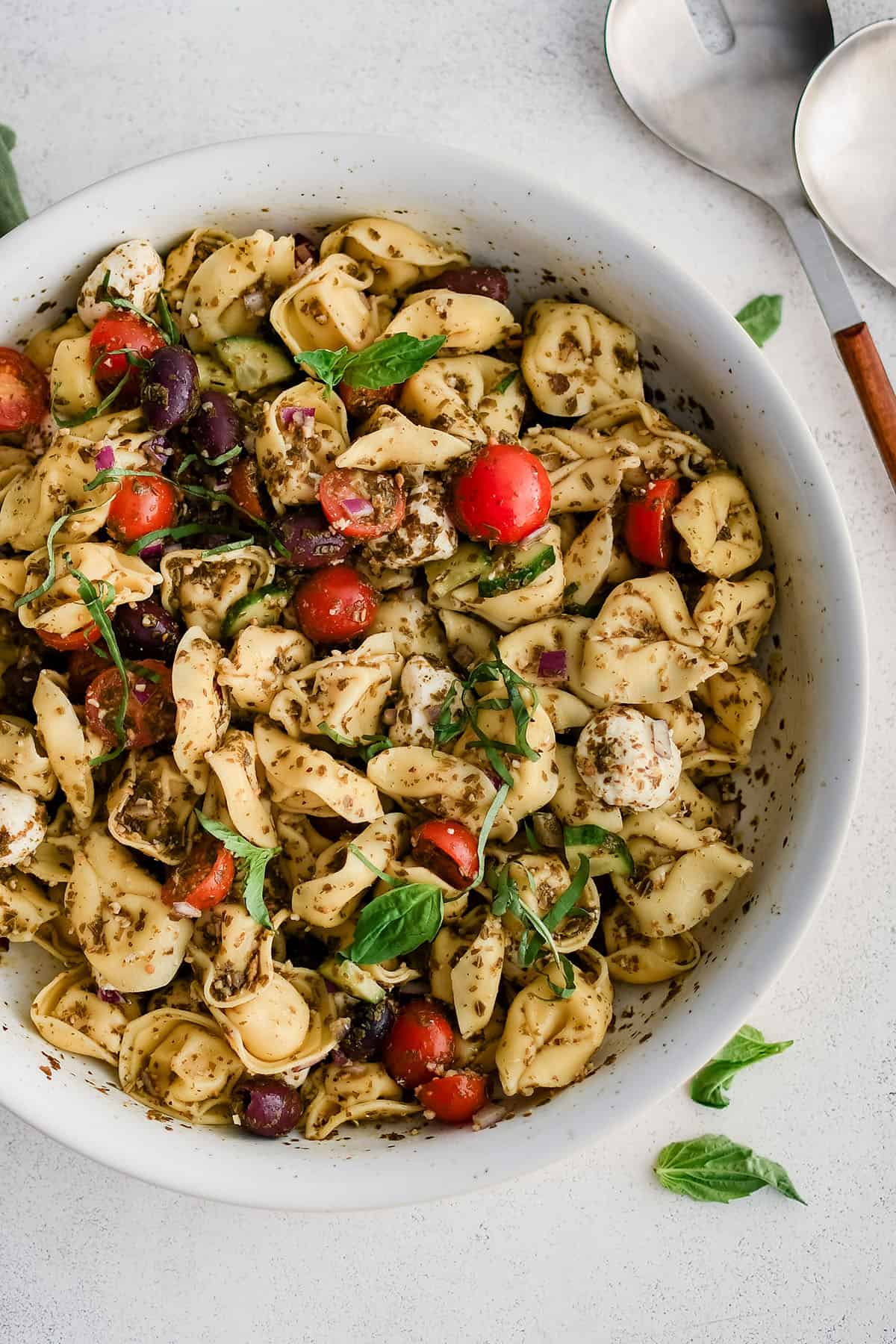 tortellini salad with pesto in a white serving bowl